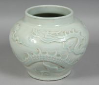 A CHINESE CELADON GLAZE JAR, with carved dragon and clouds, 16.5cm high.