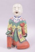 A CHINESE REPUBLIC FAMILLE VERTE PORCELAIN FIGURE OF A BOY holding a peach, 19cm high.