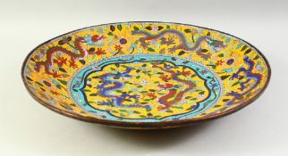 A LARGE CHINESE CLOISONNE CHARGER decorated with numerous dragons amongst flowerheads and leaves.