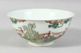A CHINESE FAMILLE VERTE PORCELAIN BOWL decorated with children in a garden, the base with a six-