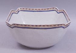 A CHINESE / EUROPEAN SQUARE FORM PORCELAIN BOWL, with red, blue and gilt work rim, 25.5cm diameter.
