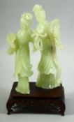 A CHINESE JADE FIGURAL GROUP ON A HARDWOOD STAND, the jade carved as two female figures, mounted