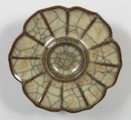 A CHINESE GE-TYPE CRACKLE-GLAZE CUP STAND, the dish formed as a flowerhead. 13cm diameter