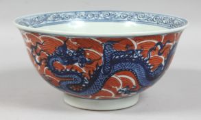 A CHINESE CORAL-RED GROUND BLUE AND WHITE PORCELAIN BOWL, the exterior decorated with dragons and