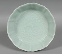A CHINESE CELADON GLAZE PETAL FORM DISH, the centre with pomegranate decoration, six character