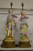 A pair of painted bisque porcelain figural lamps with ormolu bases.