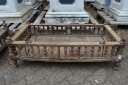 An Indian hardwood rectangular cradle or plant trough with turned spindle supports.