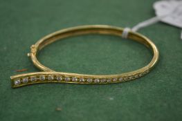 An 18ct gold and diamond bangle.