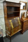 An Art Nouveau mahogany bureau bookcase with carved frieze, open shelves above a drop-flap, two
