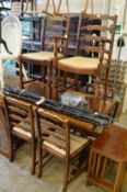 An oak refectory draw leaf dining table with six ladder back chairs, one with arms.