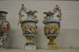 A pair of decorative continental ewers decorated with cherubs.