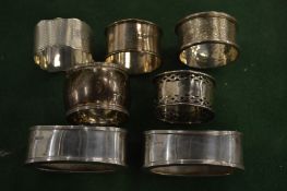Five silver napkin rings and a pair of silver salt frames.
