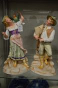A pair of continental painted bisque porcelain figures.