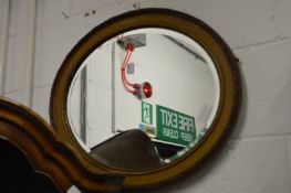A gilt framed oval mirror.