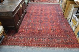 A Persian carpet, red ground with stylized decoration 295cms x 195cms.