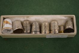 Silver thimbles and a porcelain thimble.
