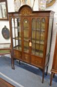 A decoratively painted Edwardian mahogany standing two-door display cabinet.