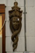 A carved wood wall mask.