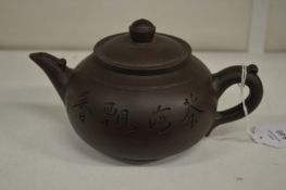 A Yixing teapot incised with calligraphy.