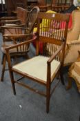 An Edwardian inlaid mahogany spindle back armchair.