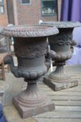 A pair of small cast iron garden urns.