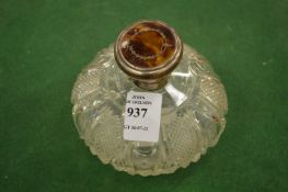 A silver and tortoiseshell topped cut glass scent bottle.