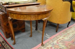 A Georgian style walnut demi-lune foldover card table.
