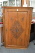A carved oak hanging corner cupboard.