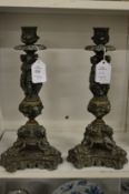 A pair of cast metal figural candlesticks.