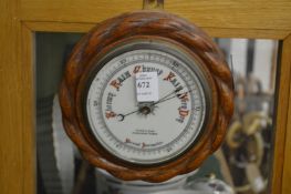 A small circular aneroid barometer.