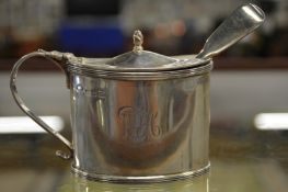 A silver oval mustard with spoon.