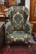 A good George II design wing back armchair on shell carved cabriole front legs with claw and ball