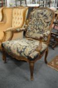 A 19th century French carved walnut framed open armchair (AF).