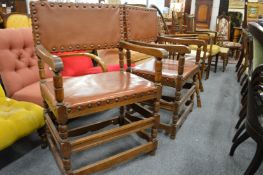 A pair of brass studded, leather cloth upholstered oak framed armchairs.