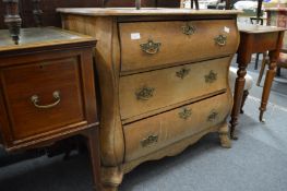 A Dutch oak bombe three-drawer chest.
