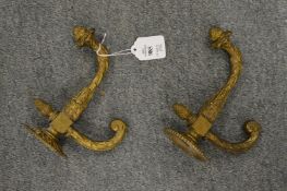 A pair of decorative cast gilt metal hooks.
