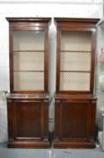 A pair of Georgian design mahogany cupboard bookcases with brass grilled doors.
