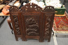 A Chinese carved wood folding screen.