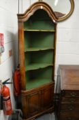 A Georgian style walnut standing corner cabinet with three open shelves above a pair of panelled