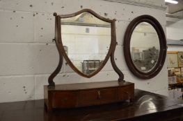 A mahogany shield shaped dressing table mirror with three drawers to the base.