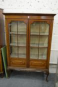 An Edwardian inlaid mahogany two door standing display cabinet.