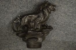 A cast metal model of a lion.