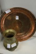 An Islamic copper dish and a cast brass vase.