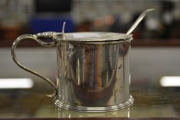 A heavy silver drum shaped mustard with spoon.