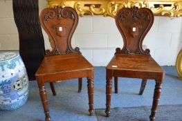 A pair of Victorian cared oak hall chairs.