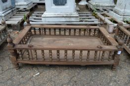 An Indian hardwood rectangular cradle or plant trough with turned spindle supports.