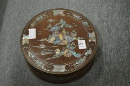 A Chinese circular hardwood box inlaid with mother-of-pearl.