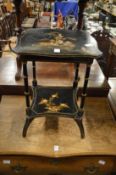 A chinoiserie decorated black lacquer two tier occasional table.
