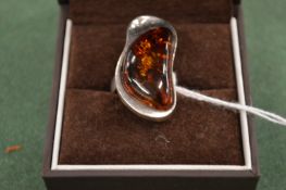 A modern silver and amber ring.