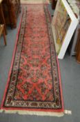 A modern Persian style pink ground floral decorated runner 370cms x 80cms.